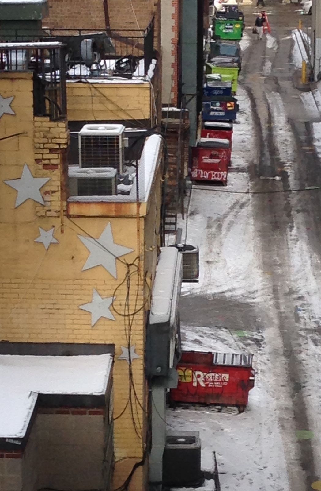 A winter alley with a red dumpster seen from above
